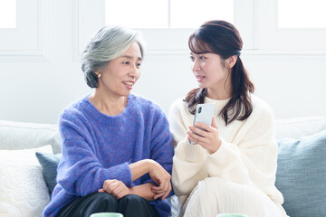 Fototapeta premium おばあちゃんにスマートフォンを教える孫娘