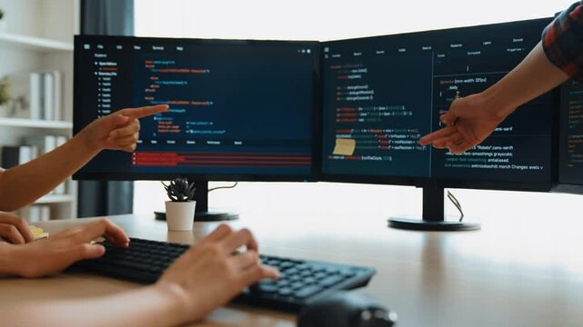 Slow motion back end software developer engineer for computer programming working together on debugging writing computing code, solving complex algorithms display on monitor in office. Burgeoning