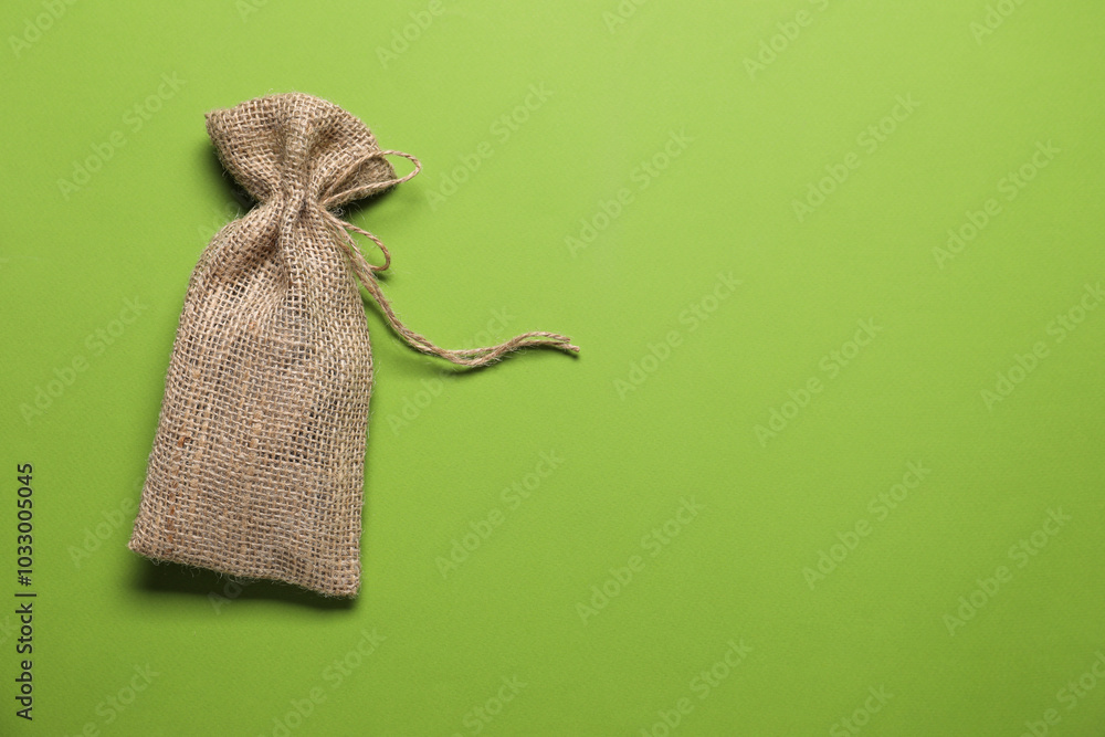 Sticker One burlap sack on light green background, top view. Space for text