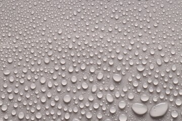 Water drops on gray background, top view