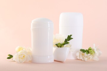 Solid deodorants and beautiful eustoma flowers on beige background