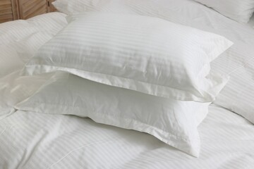 Bed with clean linens and pillows at home
