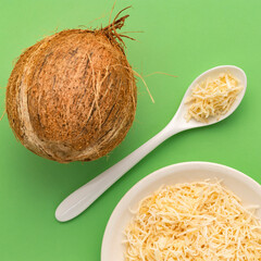Grated coconut with dehydrated sugar in the bowl and spoon - Cocos nucifera.