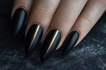 Close-up of a hand with black stiletto nails adorned with thin gold lines