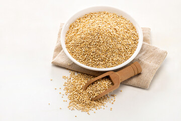 a plate of quinoa seeds on white background.