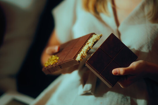 Hands holding a chocolate with pistachio filling. Person breaking in two a bog bar of chocolate 
