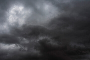 Obraz premium Dramatic dark storm rain clouds black sky background. Dark thunderstorm clouds rainny atmosphere. Meteorology danger windstorm disasters climate. Dark cloudscape storm disaster gloomy gray cloud sky