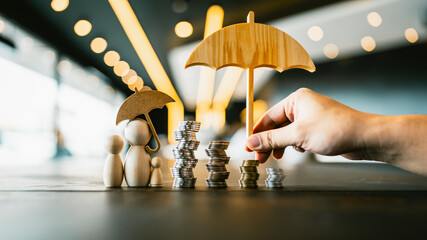 Model of family with house and coins on wooden table concept of the system of insurance savings and...