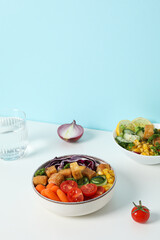 Fried tofu salad with fresh vegetables on a white table