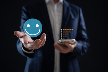 customer service evaluation and feedback rating. costumer review concept, man using phone chooses happy smiling face