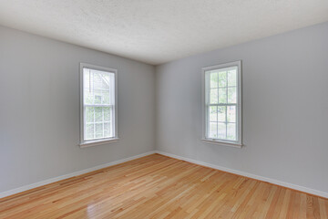 Empty Room With Light Wooden Flooring And Windows.
