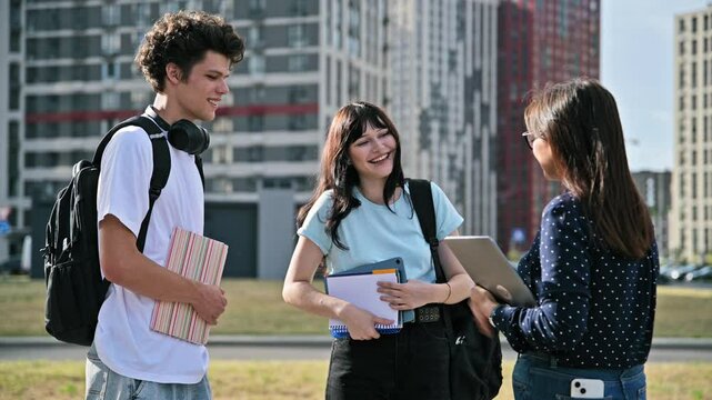 Group of college students talking with female teacher