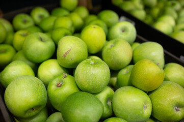 A pile of green apples in the supermarket. Agriculture. Eco-friendly product
