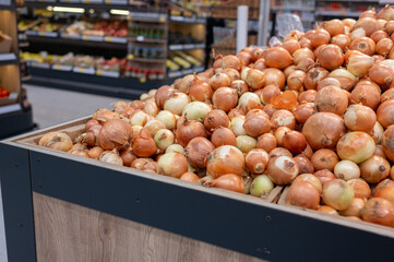 A pile of onions on the counter of a hypermarket. Eco-friendly products