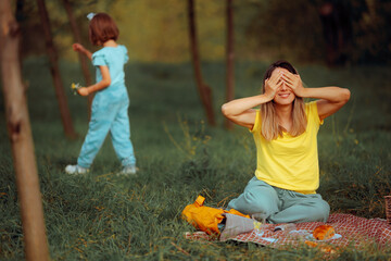 Mother Covering her Eyes Playing Hide and Seek. Mom and daughter spending quality time with games in nature
