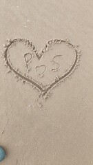 A heart is drawn on the sand on the beach at sunset.Romantic sunset on the beach.Heart shape. Heart symbol.Love.Draw a heart shape on the sandy beach in the morning. to welcome Valentine's Day.
