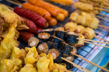 Various fried skewers meatballs and sausage, sold on the side of the road in Thailand