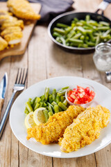 homemade breaded chicken tenders or fried fish stick with beans and tomatoes