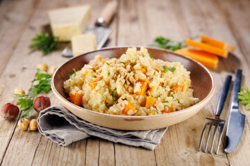 risotto with butternut and cream on wooden background