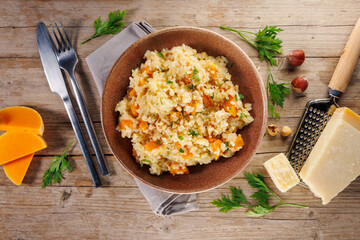 homemade creamy pumpkin risotto on wooden background