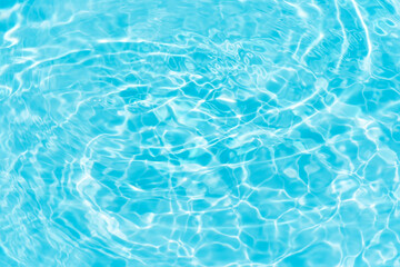 Blue water with ripples on the surface. Defocus blurred transparent blue colored clear calm water surface texture with splashes and bubbles. Water waves with shining pattern texture background.