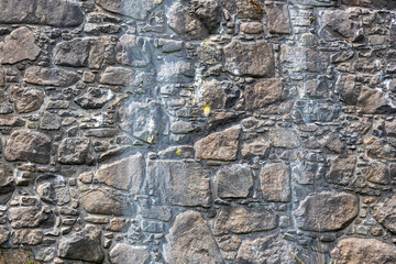 Full frame abstract texture background of a rugged medieval stone wall circa 16th century, with...