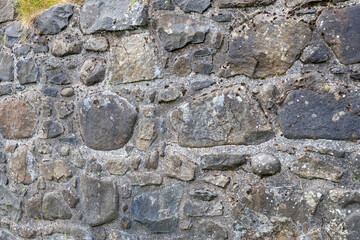 Full frame abstract texture background of a rugged medieval stone wall circa 16th century, with copy space