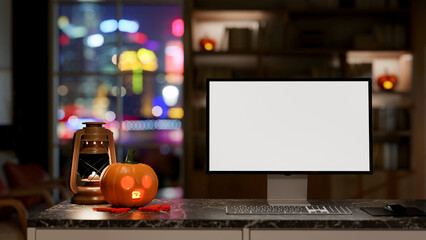 A close-up of a computer on a black marble table, featuring a lantern and a Halloween pumpkin lamp.