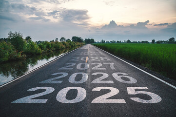 New year 2025, Text 2025 written on the road in the middle of asphalt road at sunset. Concept of...
