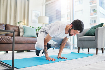 Balance, crow pose and man with yoga in home for flexibility, mindfulness and wellness exercise. Challenge, fitness and male person with kakasana position for pilates workout in living room at house.