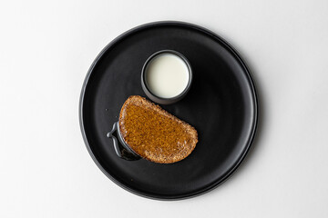 Simple Rye Bread with Honey and Milk on dark plate white background
