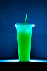 green kiwi ice or green cocktail ice in long plastic bottle and chopsticks with flashing lights on the table