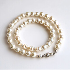 elegant white pearl necklace on a white surface with silver clasp  close up stock image