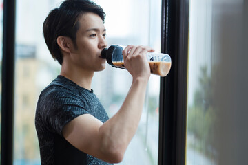 プロテインを飲む20代男性