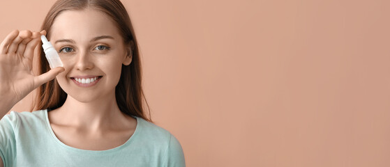 Young woman with eye drops on beige background, closeup