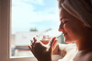 Happy woman, relax or window with tea for spa, morning routine or hygiene in cleanse at home....