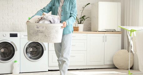 Young woman with laundry basket in room