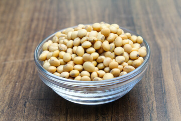 Soybean seeds in a glass bowl on wooden background 