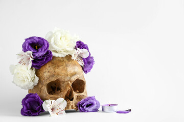 Human skull with beautiful flowers on white background