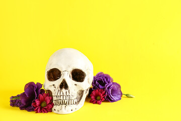 Human skull with beautiful flowers on yellow background
