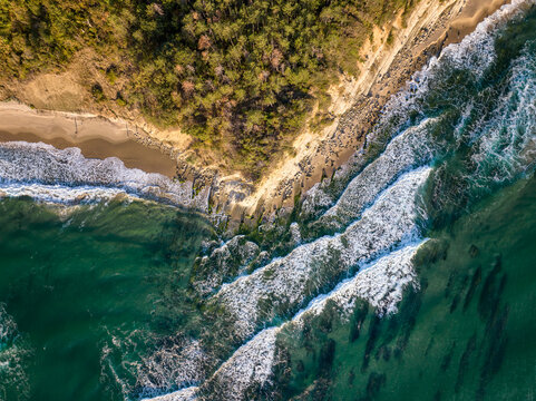 Aerial morning view of a picturesque beach with a long and empty sandbar and gentle sea waves bathed in morning sunlight on the Black Sea coast, Bulgaria.