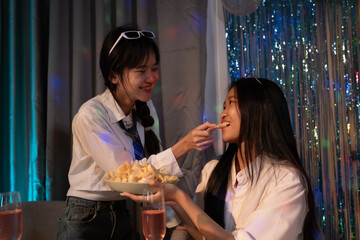 Two happy young girls laughing, drinking, sharing pizza at home party late, Friendship leisure rest home enjoy concept, sweet moment of childhood, family, celebration, friendship and home life.