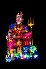 Statue of Hindu God Lord Shiva Ardhnarishwar in Meditation Posture with dramatic laser light effect