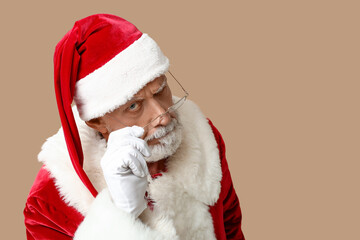 Suspicious Santa Claus in glasses on brown background