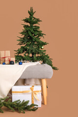 Soft bench with Christmas presents and fir tree on brown background