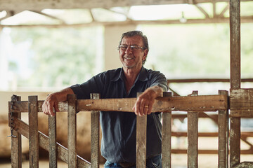 Senior man, farmer and portrait in barn with pride, happiness and sustainable business. Agro, elderly rancher and smile on estate for industry growth, environment responsibility and livestock farming © SometimesNever/peopleimages.com