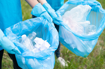 A group of happy volunteers cleaned up the riverside by collecting garbage into garbage bags and separating plastic waste from water bottles. Help keep nature clean. Reduce environmental pollution