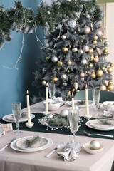 Festive table setting with burning candles and Christmas decorations in dining room