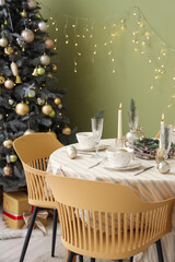 Festive table setting with Christmas decorations, reindeers and burning candles in dining room