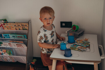 a boy with red hair just woke up and is playing in his children's room